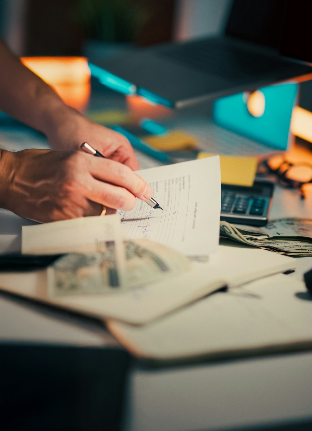 services-04 Hand signing document Polish zloty calculator finance Close-up of person filling out paperwork desk with cash calculator